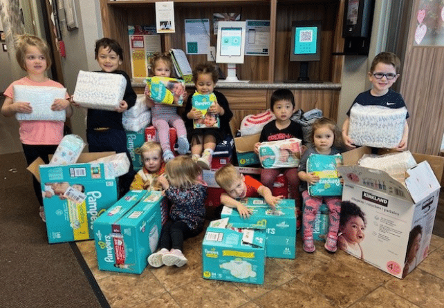 http://New%20Horizon%20Academy%20students%20holding%20boxes%20of%20diapers%20to%20be%20donated%20to%20local%20organizations%20as%20part%20of%20New%20Horizon%20Academy's%20Caring%20Beyond%20the%20Classroom%20program